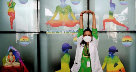 Une responsable du secteur de la santé fait du yoga durant un excercice national de préparation à la campagne de vaccination contre le coronavirus en Inde dans un hôpital gouvernemental à Chennai le 8 janvier 2021.