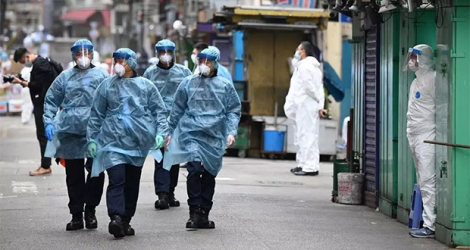 La police, en tenue de protection contre le coronavirus, patrouille dans les rues du quartier de Jordan partiellement confiné, à Hong Kong le 24 janvier 2021.