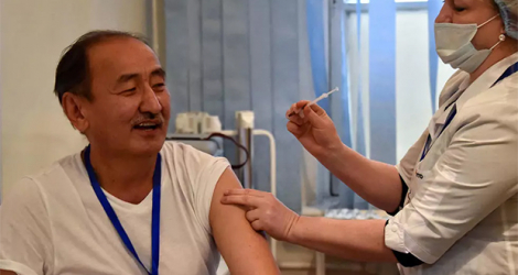 Une soignante administre le vaccin chinois Sinopharm au ministre kirghiz de la Santé Alymkadyr Beichenalïev à Bichkek le 29 mars 2021. VYACHESLAV OSELEDKO AFP