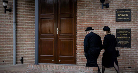 Des fidèles entrent dans l'église Sionkerk au nord des Pays-Bas, le 28 mars 2021. Photo AFP / ANP / Robin VAN LONKHUIJSEN