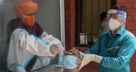 Les autorités sanitaires recueillent un échantillon d’écouvillon nasal dans un hôpital civil à Amritsar, le 24 août 2020. NARINDER NANU AFP