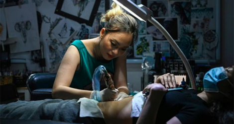 Ngoc Like réalise un tatouage sur le ventre d'une cliente dans son studio de Hanoï, le 20 mars 2021 au Vietnam afp.com - Manan VATSYAYANA