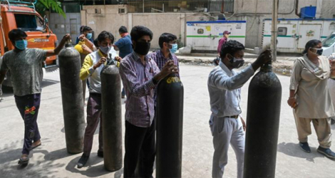 Des gens attendent pour remplir des bouteilles d'oxygène à New Delhi le 12 mai 2021. afp.com - Prakash SINGH