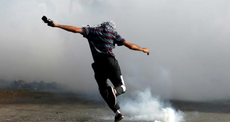 Un manifestant palestinien donne un coup de pied à une grenade lacrymogène lors d'afffrontements avec la police à Beit El, près de Ramallah, territoires occupés, le 21 mai 2021. afp.com - ABBAS MOMANI