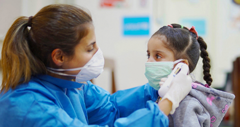 Une infirmière prend la température d'une fille dans un centre de soins de santé primaires à Beyrouth, au Liban, pendant la pandémie de Covid-19.