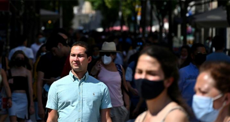 Des piétons avec masque ou sans masque dans une rue de Madrid, le 26 juin 2021.