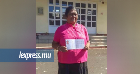 Tara Mudhoo tenant fièrement son permis de conduire.