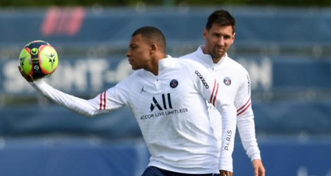 Les joueurs du Paris Saint-Germain, le Français Kylian Mbappé (gauche) et l'Argentin Lionel Messi (derrière), prennent part le 28 août 2021 à un entraînement au Camp des Loges, à Saint-Germain-en-Laye.