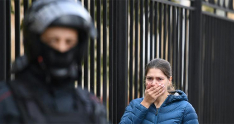 Une femme en proie à l'émotion à l'entrée du campus de l'université de Perm (Russie), le 21 septembre 2021, au lendemain d'une tuerie qui a coûté la vie à six personnes.