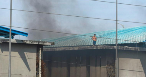 Un détenu sur le toit de la prison de Guayaquil pendant des affrontements, le 28 septembre 2021.
