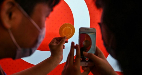 Des clients prennent une photo d'un dalgona, une galette au sucre croustillante, présentée dans la série de Netflix «Squid Game», le 12 octobre 2021 à Shanghai.