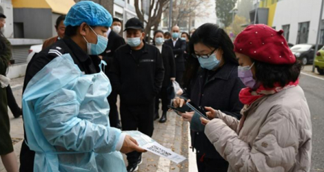 Des habitants de Pékin scannent un QR code avant de se faire tester contre le Covid-19, le 4 novembre 2021.