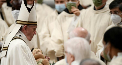 Le pape François porte un bébé Jésus au Vatican le 24 décembre 2021.
