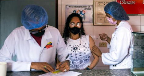 Une femme reçoit le vaccin chinois Sinovac contre le Covid-19 sur son lieu de travail à Caracas, le 22 janvier 2022.