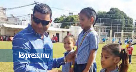 Sanjit Bundhoo remet des médailles à des écoliers après avoir sponsorisé une journée sportive. 