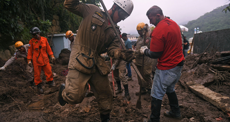 Des secouristes creusent à la recherche de disparus, le 19 février 2022, dans le quartier de Caxambu à Petropolis, au Brésil, ville ravagée par des glissements de terrain dus à des pluies torrentielles.