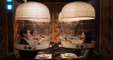 Des membres du personnel d'un hôtel présentent des lanternes destinées à protéger du coronavirus les convives ne portant pas de masque sanitaire, à Tokyo le 28 février 2022.