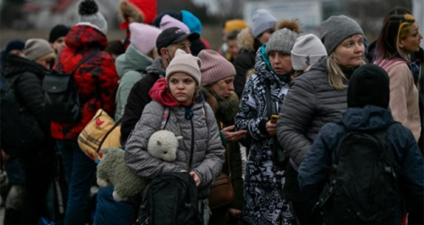 Des réfugiés attendent des cars du côté polonais de la frontière avec l'Ukraine, à Medyka, le 6 mars 2022.