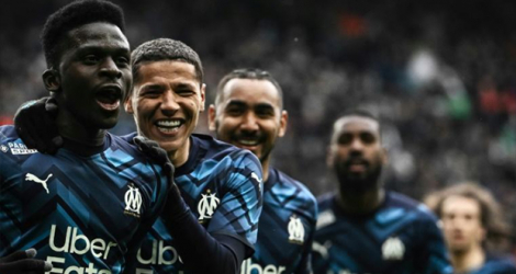 La joie de l'attaquant sénagalais de Marseille Bamba Dieng, félicité par ses coéquipiers, après son but marqué contre Saint-Etienne, lors de la 30e journée de Ligue 1, le 3 avril 2022 au Stade Geoffroy-Guichard.