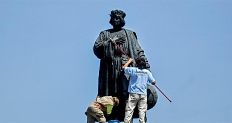 Des employés municipaux nettoient la statue de Christophe Colomb à Mexico, le 12 octobre 2020.
