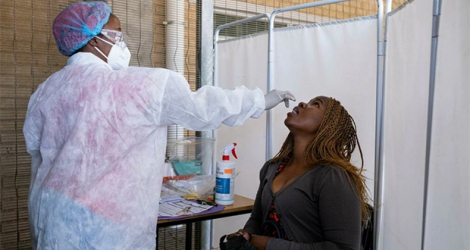 Un personnel médical procède à un test PCR de dépistage du Covid-19 au laboratoire Lancet à Johannesburg, le 30 novembre 2021.