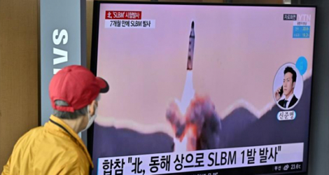 Passant regardant un tir de missile nord-coréen sur un écran de la gare de Séoul, le 7 mai 2022.