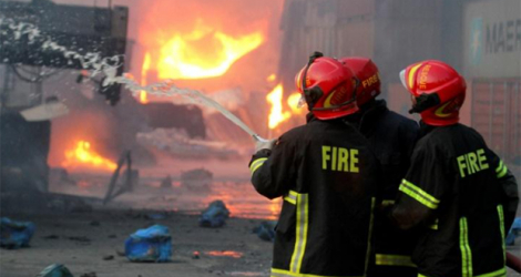 Des pompiers luttent contre un incendie dans un entrepôt de conteneurs, le 5 juin 2022 à Sitakunda, au Bangladesh.