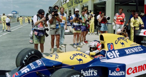 Des photographes se pressent autour de la monoplace du Britannique Nigel Mansell, avant les essais du dernier GP d'Afrique du Sud, le 28 février 1992, sur le circuit de Kyalami.