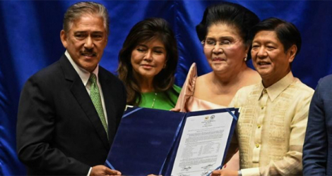 Le président élu Ferdinand Marcos Jr (d) tient le document de sa proclamation, aux côtés du président du Sénat, Vincente Sotto III, de sa mère Imelda Marcos (2e d) et et de la sénatrice Imee Marcos-Manotoc, le 25 mai 2022 à Quezon City, près de Manielle, aux Philippines.