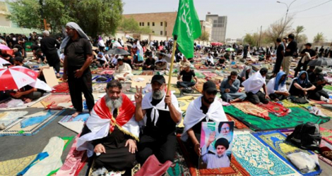 Des partisans du chef chiite irakien Moqtada Sadr se réunissent pour la prière du vendredi le 12 août 2022 à côté du Parlement à Bagdad.