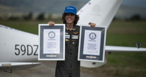 Mack Rutherford montre le certificat du Guiness World Record du plus jeune pilote à accomplir un tour du monde en solitaire, le 24 août 2022 sur le tarmac de l'aroport de Radomir, près de Sofia, en Bulgarie.