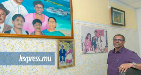 Indiren Parasuraman posant devant des photos de famille.