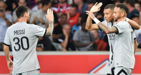 L'attaquant français du Paris SG Kylian Mbappé célèbre un but avec l'attaquant argentin Lionel Messi (à gauche) et l'attaquant brésilien Neymar (tout à droite) lors d'un match de Ligue 1 contre Lille au Stade Pierre-Mauroy de Villeneuve-d'Ascq, le 21 août 2022.