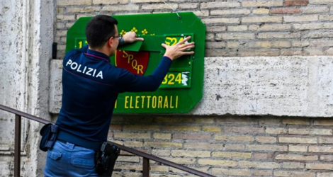 Un policier met en place l'affichage d'un bureau de vote à Rome le 24 septembre 2022.
