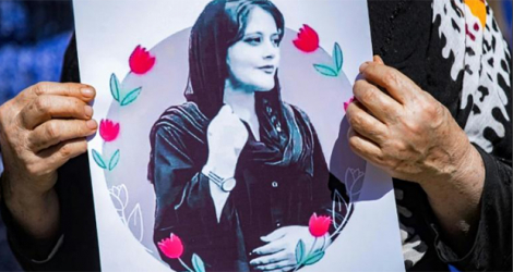 Une femme tient une photo de Mahsa Amini, une jeune Iranienne morte après avoir été arrêtée par la police, lors d'une manifestation à Hassaké, dans le nord-est de la Syrie, le 25 septembre 2022.
