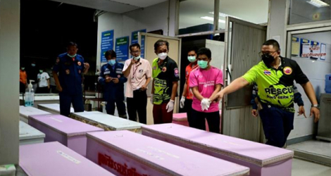 Un secouriste compte les cercueils contenant les corps des victimes à la morgue de l'hôpital d'Udon Thani, en Thaïlande, le 7 octobre 2022.