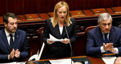La nouvelle Première ministre Giorgia Meloni (c) s'adresse au Parlement , entourée du ministre des AE Antonio Tajani (D) et de son allié le député Matteo Salvini (g), le 25 octobre 2022.