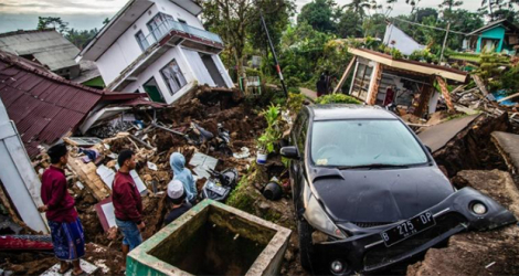 Des habitants récupèrent leurs affaires dans leurs maisons endommagées, suite à un séisme de magnitude 5,6 qui a fait au moins 162 morts, des centaines de blessés et des disparus à Cianjur, le 22 novembre 2022.
