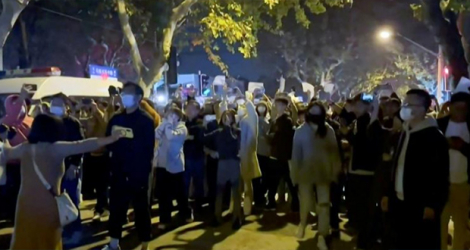 Cette image tirée de la vidéo d'un témoin oculaire mise à disposition par l'AFPTV le 27 novembre 2022 montre des manifestants criant des slogans à Shanghai.