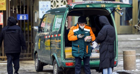 Un livreur de colis dans une rue d'Urumqi, capitale de la région du Xinjiang, le 1ᵉʳ décembre 2022 dans le nord-ouest de la Chine.