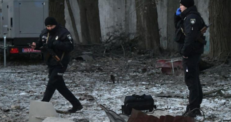 Des secouristes et des policiers ukrainiens examinent les restes d'un drone après une attaque russe sur un bâtiment administratif, le 14 décembre 2022 à Kiev.