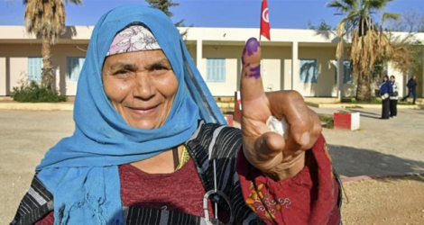 Une électrice tunisienne montre son doigt taché d'encre après avoir voté aux Législatives, dans un bureau de Mnihla, près de Tunis, le 17 décembre 2022.