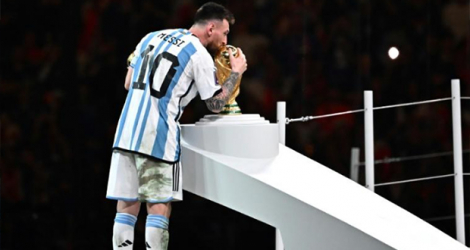 La superstar de l'Argentine Lionel Messi embrasse le trophée de la Coupe du monde après avoir été désigné meilleur joueur de la compétition, le 18 décembre 2022 à Doha.