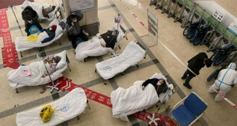 Des patients atteints du Covid-19 attendent sur des lits dans le hall d'accueil de l'hôpital No.5 de Chongqing, le 23 décembre 2022 dans le sud-ouest de la Chine.