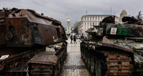 Des passants observent des chars russes détruits lors d'une exposition en plein air à Kiev le 5 janvier 2023.