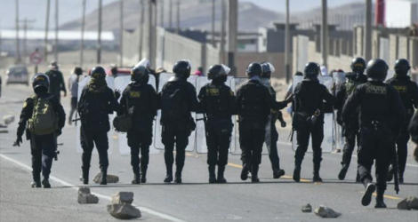 Des policiers en position sur l'autoroute panaméricaine, le 12 janvier 2023 à Arequipa, au Pérou.