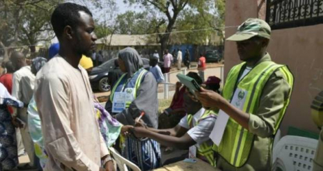 Un agent électoral vérifie l’identité d’un électeur, le 25 février 2023, à Yola, lors des élections au Nigeria. afp.com – Pius Utomi Ekpei