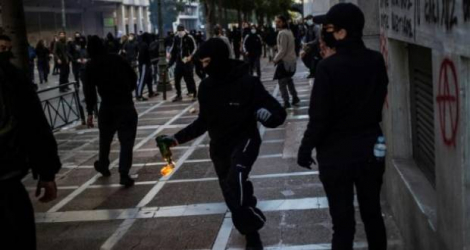 Un manifestant avec un cocktail Molotov allumé à la main durant une manifestation le 8 mars 2023 à Athènes après la catastrophe ferroviaire qui a fait 57 morts. afp.com - Angelos Tzortzinis    