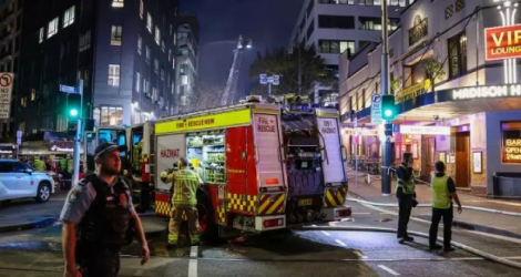 Plus d'une centaine de pompiers tentent jeudi d'éteindre un violent incendie d'un immeuble de sept étages à Sydney, qui se propage à d'autres bâtiments. AFP David Gray