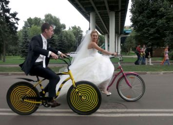 Russie : Boris Babkini et son épouse Yelena traversant Gorky Park à vélo après la célébration de leur mariage à Moscou. 